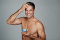 Smiling while hes styling. Cropped portrait of a handsome mature man styling his hair with gel. Royalty Free Stock Photo