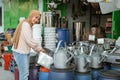 Smiling hijab woman stands when holding watering can