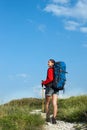 Smiling hiking young woman on the mountain trail