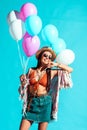 Smiling Hippie woman in sunglasses holding colored balloons Royalty Free Stock Photo