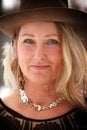 Smiling hippy woman with blue eyes outdoors wearing cowboy hat with feathers and silver jewelry Stevie Nicks vibe Royalty Free Stock Photo