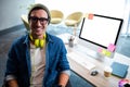 Smiling hipster businessman posing for camera while sitting at desk Royalty Free Stock Photo