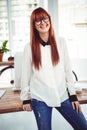 Smiling hipster businesswoman front of her desk