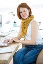 smiling hipster businesswoman sitting at her desk Royalty Free Stock Photo