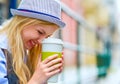 Hipster girl with cup of hot beverage on city street Royalty Free Stock Photo