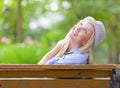 Smiling hipster girl sitting on bench in the city park Royalty Free Stock Photo