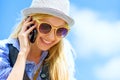 Hipster girl talking mobile phone against sky Royalty Free Stock Photo