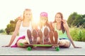 Smiling hipster teenage friends with skateboard, colorised image with sunflare