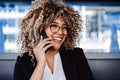 Smiling hispanic afro business woman wearing eye glasses in cafe using laptop and mobile phone Royalty Free Stock Photo