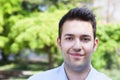 Smiling hispanic guy in a blue shirt outside in a park Royalty Free Stock Photo