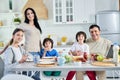 Eating together. Smiling hispanic parents spending time with their little children, having breakfast together at home Royalty Free Stock Photo