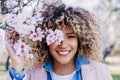 Smiling hispanic woman with eyes closed in park enjoying sunny day. Spring flowers background Royalty Free Stock Photo