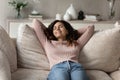 Smiling Hispanic woman relax on sofa taking nap Royalty Free Stock Photo