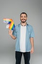 Smiling homosexual man holding lgbt flags
