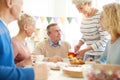 Hospitable lady pouring tea to friends Royalty Free Stock Photo