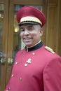 Smiling hotel bellman with red jacket on, in Rome, Italy, Europe