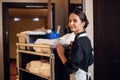 Smiling hotel maid with fresh towels doing housekeeping