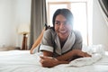 Smiling hotel maid lying on a bed