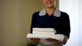 Smiling hotel worker showing clean pillows, good housekeeping, health standard