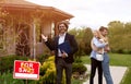 Smiling house agent and happy couple embracing in front yard of their new property Royalty Free Stock Photo