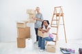 Smiling housemates carrying cardboard moving boxes