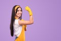 Smiling housewife in apron and gloves showing biceps Royalty Free Stock Photo