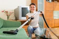 Smiling housewife cleaning sofa