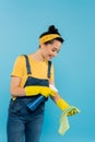 smiling housewife spraying detergent on rag