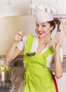 Smiling housewife tasting soup with ladle