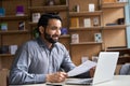 Smiling indian business man holding cv document having virtual job interview. Royalty Free Stock Photo