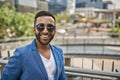 Smiling Indian businessman standing with city buildings in background