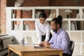 Smiling Indian businesswoman mentor training African American intern in office Royalty Free Stock Photo