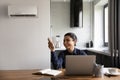 Smiling Indian businesswoman using air conditioner remote controller at home Royalty Free Stock Photo