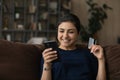 Smiling Indian female buyer shopping online on smartphone