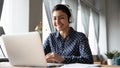 Smiling Indian girl wearing headphones using laptop, working online Royalty Free Stock Photo