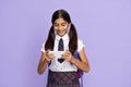 Indian school girl holding phone watching online class  on background. Royalty Free Stock Photo