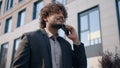 Smiling Indian male Arabian guy walking near office building Hispanic happy ethnic man businessman laughing entrepreneur Royalty Free Stock Photo