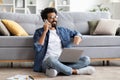 Smiling Indian Man Talking On Cellphone And Working With Laptop At Home Royalty Free Stock Photo