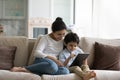 Smiling Indian mother with 5s son using tablet at home