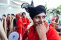 Smiling Indian musician guy wearing red Bandhgala and black Pheta at Indian wedding ceremony in Bangkok, Thailand