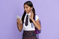 Smiling indian school girl video calling on mobile phone isolated on background. Royalty Free Stock Photo