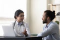 Smiling Indian woman doctor consulting African American man, giving recommendation Royalty Free Stock Photo