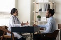 Smiling Indian woman doctor talking, consulting African American patient Royalty Free Stock Photo