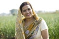 Smiling Indian woman farm owner standing in agricultural field