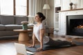 Smiling Indian woman practicing yoga online, working out at home Royalty Free Stock Photo