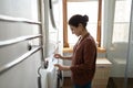 Smiling Indian woman turning on washing machine, doing housework Royalty Free Stock Photo