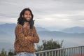 A smiling Indian young man with long hair and beard looking at camera while posing with crossed arms Royalty Free Stock Photo