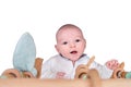 Smiling infant baby boy playing with a wooden mobile suspended abov Royalty Free Stock Photo