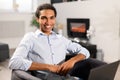 Smiling intelligent multiracial male freelancer in smart casual shirt using laptop for work