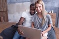 Smiling international couple making online purchase at home